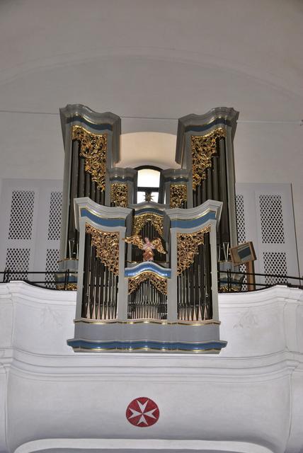 Den Maltesern gehören Grund und Bau der Pfarrkirche Fürstenfeld – auf dem linken Bild ihr Kreuz unterhalb der Orgel. – Behinderten Menschen aus ganz Österreich, hier in Wien, ermöglichen die Malteser mit ihrem Sonderzug eine Reise nach Lourdes. | Foto: Neuhold, Rupprecht