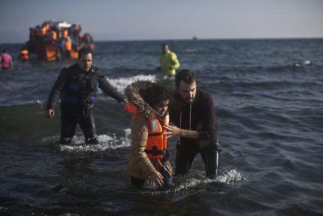 August 2015. Ein Helfer unterstützt ein Flüchtlingsmädchen auf dem Weg zum Land.