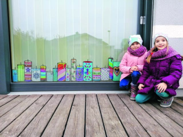 Tina und Tessa Berger vor einem adventlich gestalteten Fenster in Wolfpassing.