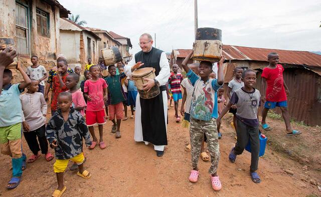 Pater Karl Wallner mit Kindern trommelnd in Afrika. | Foto: Missio