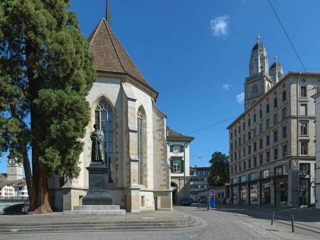 Marys Foto aus Zürich: Die Wasserkirche mit Zwingli-Denkmal, rechts die Türme des Großmünsters.