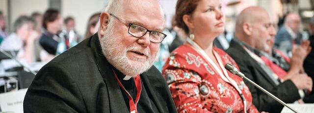 Bischöfe wie Kardinal Reinhard Marx sitzen bei den Vollversammlungen des Synodalen Wegs in alphabetischer Reihenfolge neben Nicht-Bischöfen. Diese Durchmischung gefällt nicht allen.
 | Foto: Julia Steinbrecht/KNA