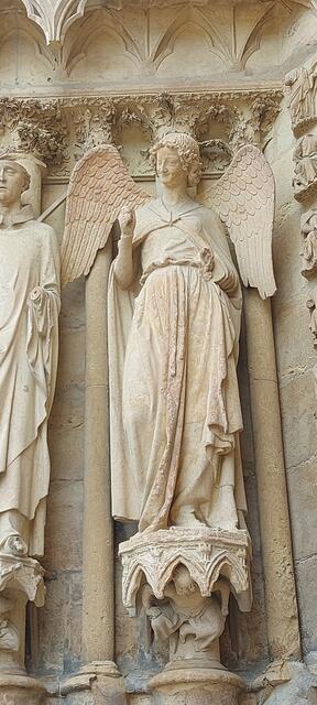 Der Lächelnde Engel (französisch L’Ange au Sourire oder Sourire de Reims – ‚Das Lächeln von Reims‘) ist eine um 1250 entstandene Skulptur im gotischen Stil an der Westfassade der Kathedrale von Reims. | Foto: Andrea Reich