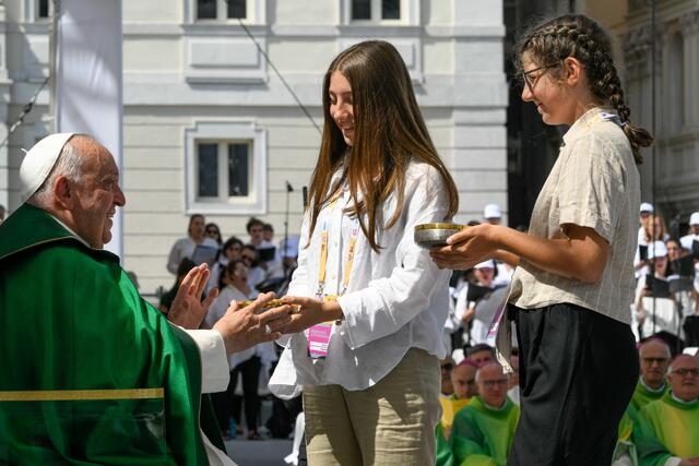 Zwei junge Frauen bringen Papst Franziskus die Gaben beim Open-Air-Gottesdienst in Triest. | Foto: KNA