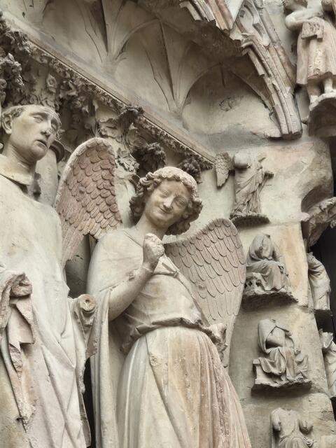 Reims. Der Lächelnde Engel an der Fassade der Kathedrale von Reims berührt mit seinem heiteren, verhaltenen Lächeln. 