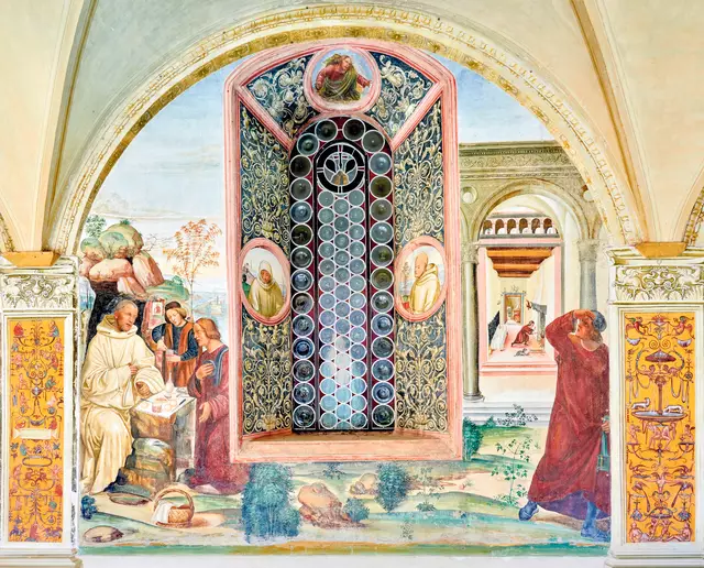 Der Ausschnitt aus einem Fresko in der Abtei von Monte Oliveto zeigt den heiligen Benedikt, wie er gerade vom Priester und dessen Helfer besucht wird. Das Gemälde wurde um 1505 von Giovanni Antonio Bazzi, genannt Sodoma, gemalt.Monte Oliveto, südlich von Siena gelegen, ist berühmt für seinen Kreuzgang. Dieser ist geschmückt mit einem Zyklus von 36 Fresken von Luca Signorelli und Sodoma. Die wandhohen Gemälde schildern das Leben des heiligen Benedikt und gelten als einer der schönsten Freskenzyklen der Renaissance. | Foto: rita guglielmi / Alamy Stock Photo