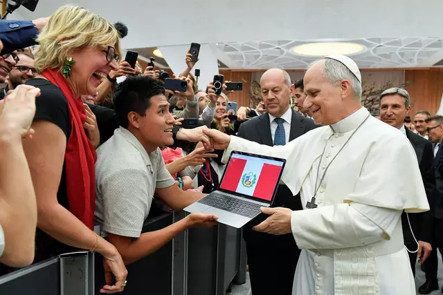 Papst Leo XIV. spricht mit einem Mann, offensichtlich aus Peru, bei einem Treffen mit Vertretern der Medien in der Audienzhalle im Vatikan. 
 | Foto:  Vatican Media/Romano Siciliani/KNA