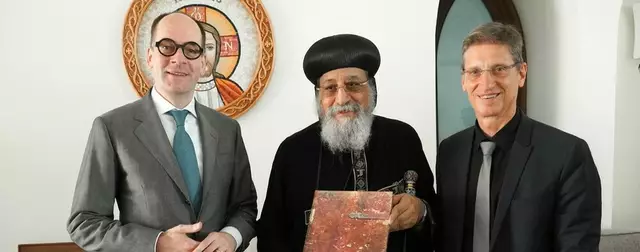 Botschafter Georg Pöstinger (l.) und Dekan Dietmar Winkler (r.) übergeben die Armenbibel an Papst Tawadros II. (Mitte).  | Foto: kathpress