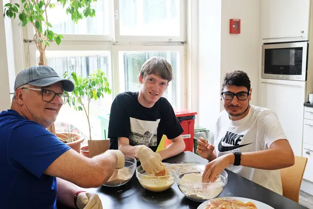 Sidney Aloys (Mitte) beim Schnitzel panieren in der 
Wirkstatt Dreiheiligen des slw Innsbruck.   | Foto: Hölbling