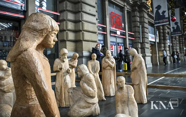 Mitten unter euch. Die lebensgroßen Holzfiguren der Krippe am Frankfurter Hauptbahnhof an Heiligabend 2024 erinnern daran, dass Jesus nicht in einem Palast zur Welt kam, sondern mitten unter jenen, die ihn brauchen. | Foto: Harald Oppitz/KNA (2)