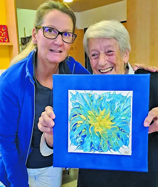 Die Heim-Bewohnerin freut sich über das Bild, das sie gemeinsam mit Michaela Stenzel gemalt hat.  | Foto: Patricia Harant-Schagerl