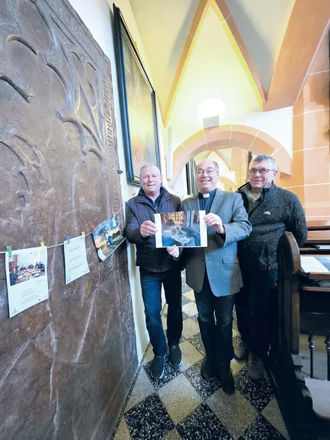 V. li.: Pfarrsekretär Thomas Pflügl, Pfarrer Hans Lagler und Mesner Franz Mittergeber zeigen das Bild, auf dem Paul das Jesus-Kind umarmt, nachdem seine Großmutter vom Krankenhaus nach Hause gekommen ist. | Foto: Wolfgang Zarl