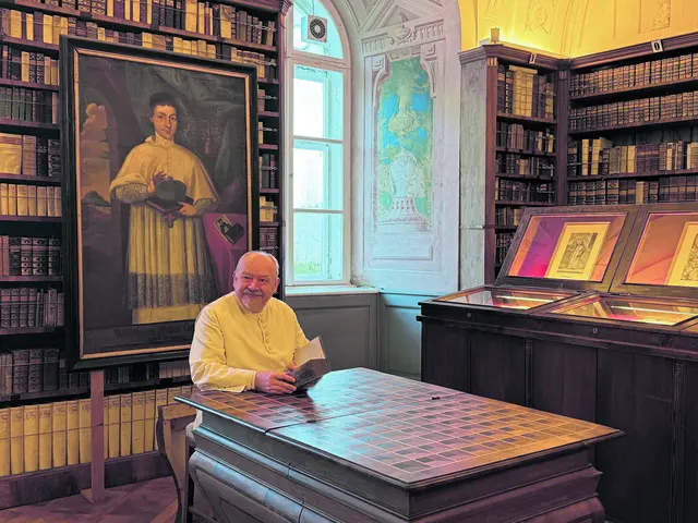 Herr Benedikt sitzt an einem Pult, das sich zu einer Treppe hochklappen lässt. | Foto: Patricia Harant-Schagerl