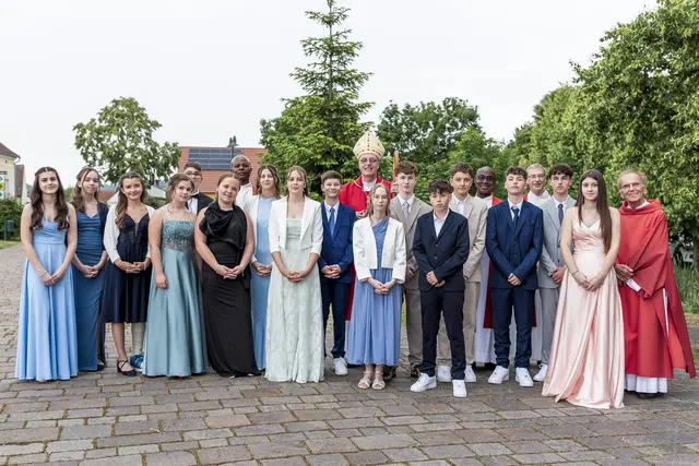 Gruppenfoto zur Firmung in Königsdorf mit dem Bischof, den Priestern und dem Diakon.