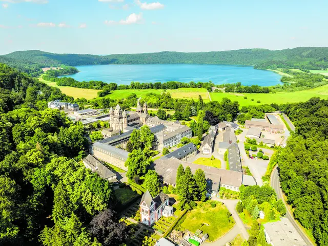 Links: Das Klostergelände am Laacher See. Rechts: Detailaufnahme der mächtigen romanischen Basilika.  | Foto: Eifel Tourismus GmbH / Dominik Ketz