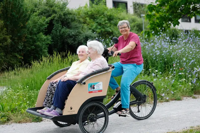 Lotte (li.) und Erika bei der Ausfahrt mit der Rikscha. Hinter ihnen tritt Ulli Mariacher in die Pedale. | Foto: Walter Hölbling