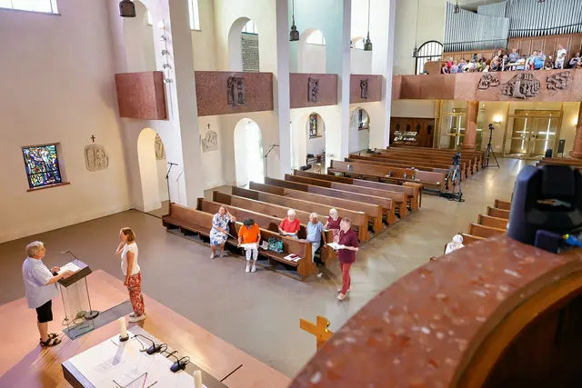 Generalprobe am Tag davor. Noch nicht in Festtagskleidung, aber hoch konzentriert sind alle Mitwirkenden am Tag vor der Live-Übertragung in der Pfarrkirche Graz-Münzgraben. Am Samstag, dem 8. August, wurden Mikrofone eingestellt, die Dauer der einzelnen Beiträge gestoppt und Kameras platziert – selbst auf der Kanzel (rechts im Bild). Am Chor warteten neben dem Sommerchor und dem Organisten auch GesangssolistInnen und InstrumentalistInnen auf ihren Einsatz. Am Sonntag drauf wurde dann live gesendet.